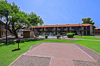 A brick pathway leads to a BBQ grill in front of the pool at Sahuaro West in Phoenix, AZ